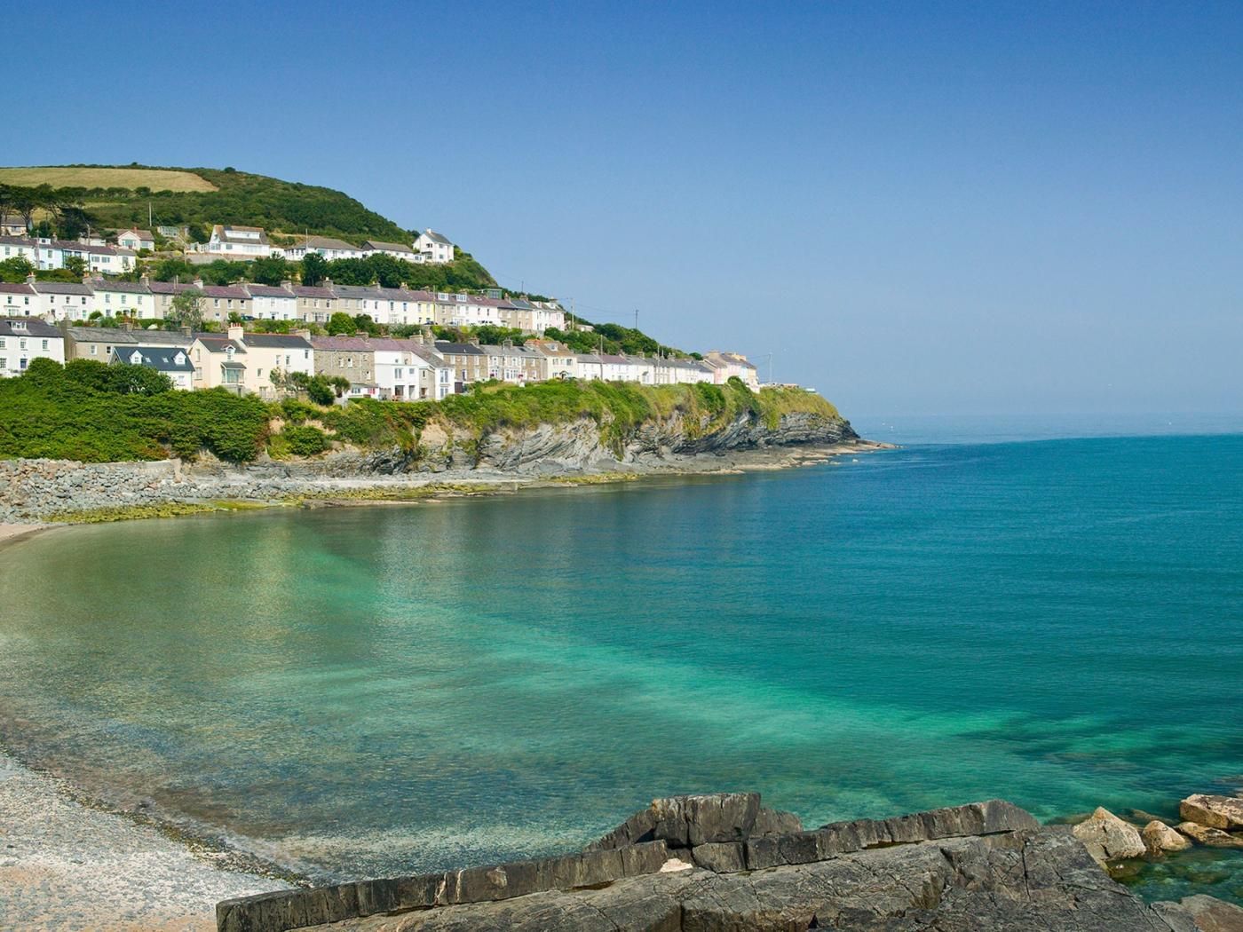 A coastal town with buildings on a hillside overlooking the sea.