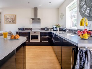 A modern kitchen with a central island, built-in oven, and a large window. - 3 Bed in Shanklin (oc-ic180) (Shanklin)
