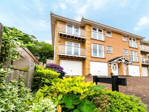 A multi-story residential building with a brick facade, white-framed windows, and a gated entrance. - 3 Bed in Shanklin (oc-ic180) (Shanklin)