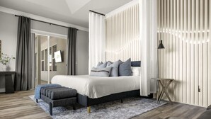 Une chambre moderne avec un lit, une table de chevet et une vue sur un balcon.