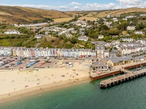 A coastal town with colorful buildings, a sandy beach, and a pier extending into the water. - 1 Bed in Aberdovey (oc-87910) (Aberdovey)