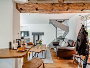 A modern living space with a wooden ceiling, a fireplace, a sofa, and a staircase. - 1 Bed in Kendal (oc-94210) (Kendal)