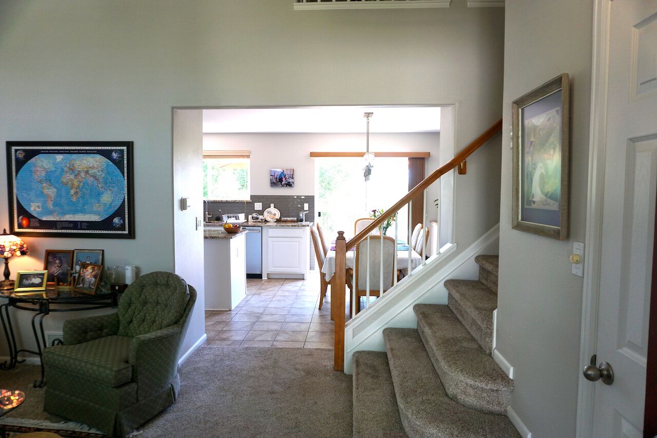 Un intérieur de maison comprenant un coin repas, une cuisine et un escalier.