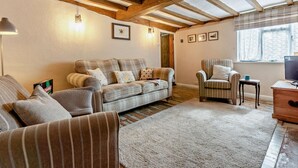 A cozy living room with a sofa, armchairs, a small table, and a television. - 2 Bed in Hastings (oc-94200) (Pett)