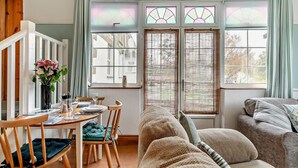 A cozy living room with a dining area, a sofa, and a window with a view. - 1 Bed in Redruth (oc-90897) (Redruth)