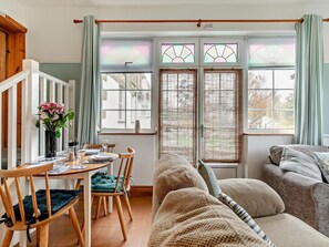 Ein gemütliches Wohnzimmer mit Essbereich, einer Couch und einem Fenster mit Blick.