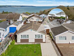 A residential area with houses, a blue garage door, and a grassy lawn. - 2 Bed in Saundersfoot (oc-94207) (Saundersfoot)
