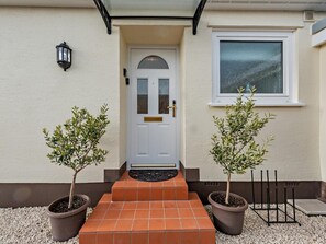 A house with a white door, two potted trees, and a window. - 2 Bed in Saundersfoot (oc-94207) (Saundersfoot)