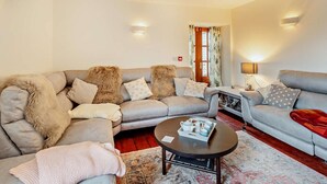 Ein Wohnzimmer mit zwei Sofas, einem Couchtisch und einer Lampe.