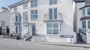 En toetagers bygning med et karnapvindue, en fordør og en lille balkon.