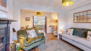 A living room with a fireplace, two sofas, a rug, and a kitchen visible through an open door. - 2 Bed in Middlesbrough (oc-94220) (Great Broughton)