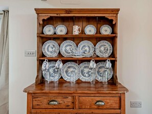 A wooden cabinet with multiple shelves holding various ceramic dishes and glassware. - 1 Bed in Blandford Forum (oc-94279) (Okeford Fitzpaine)