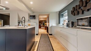 Cocina moderna con una isla central, electrodomésticos integrados y vistas al área de comedor.