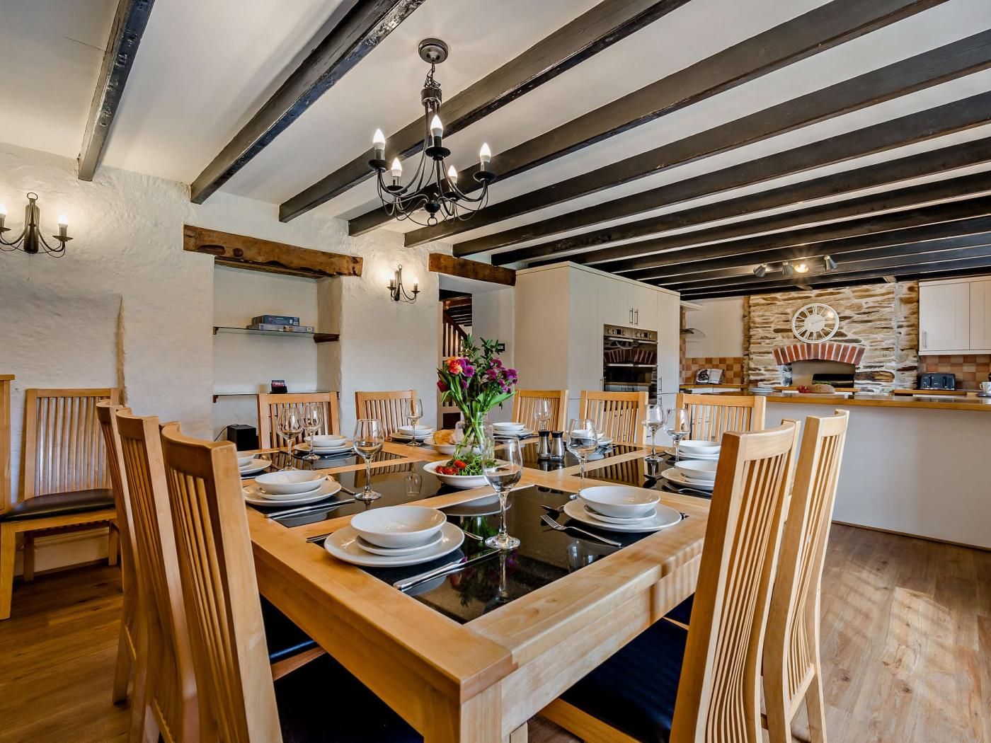 Ein Essbereich mit einem Holztisch, der für eine Mahlzeit gedeckt ist, umgeben von Stühlen.