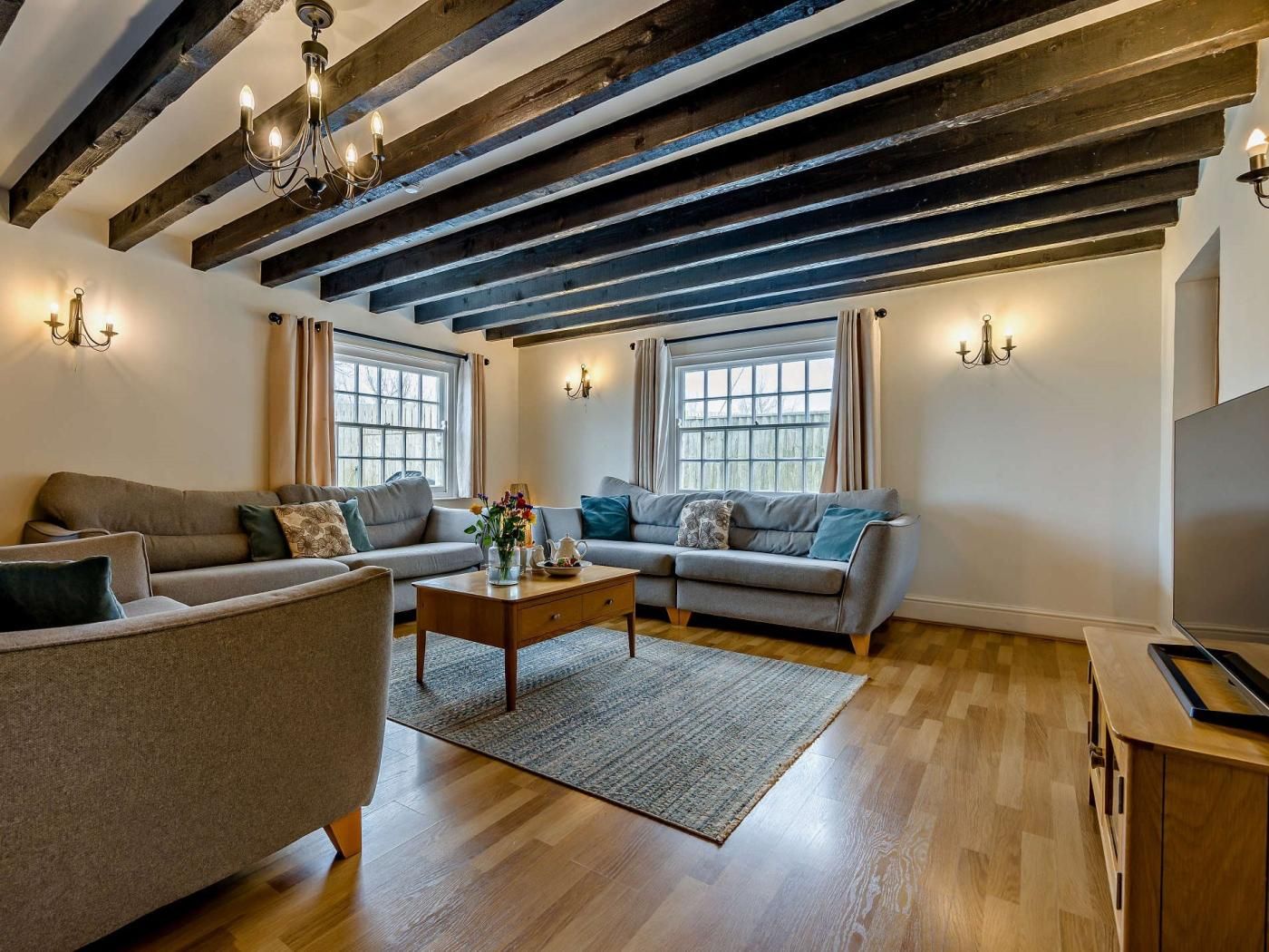 A living room with two sofas, a coffee table, and a TV stand.
