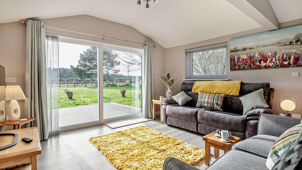 Ein modernes Wohnzimmer mit Sofa, Couchtisch, Teppich und einem Gemälde an der Wand.