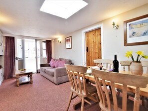 Ein gemütliches Wohnzimmer mit einer Couch, einem Holzesstzimmer und Stühlen.