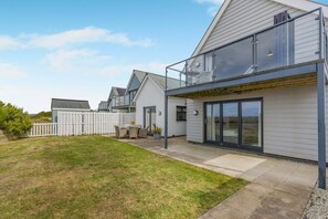 A modern residential building with a covered patio, a fenced backyard, and a view of the surrounding area. - 4 Bed in Bideford (oc-74251) (Northam)