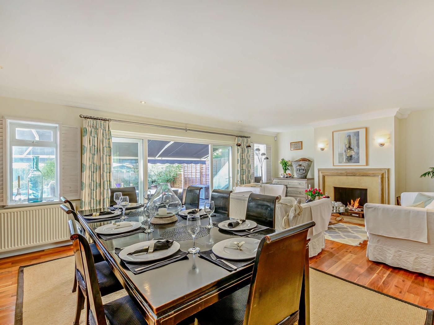 A dining area with a table set for four, a fireplace, and a view of the outdoors.