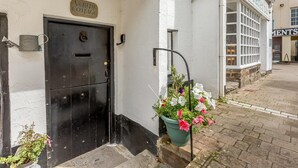 Un edificio blanco con una puerta negra que dice 'Verity Cottage' y un cartel de 'The Starter Bar' a la derecha.