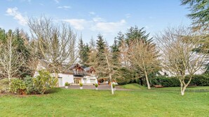 A house with a front porch, surrounded by trees and a well-maintained lawn. - 3 Bed in Perth (oc-50031) (Stanley)