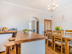 A kitchen with a wooden island, a radio, and a bowl of fruit. - 8 Bed in Hunstanton (oc-89469) (Hunstanton)