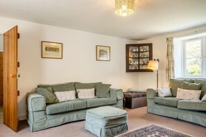 A cozy living room with two sofas, a cabinet with dishes, and a lamp. - 3 Bed in Ventnor (oc-ic179) (Godshill)