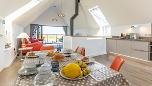 En moderne loftlejlighed med spiseplads, køkken og opholdsstue.