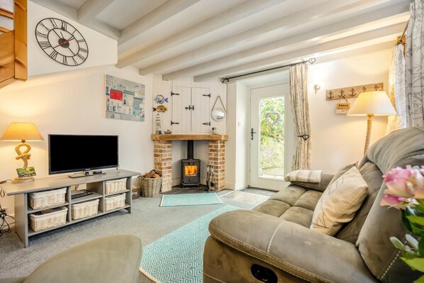 Una sala de estar acogedora con chimenea, televisor y asientos cómodos.