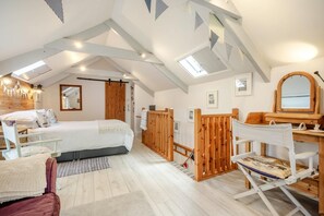 Un dormitorio con cama, escritorio, silla y espejo.