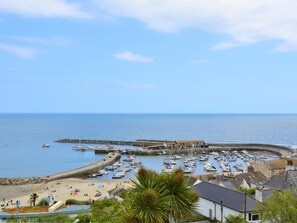 A coastal town with a marina, sandy beach, and buildings along the waterfront.