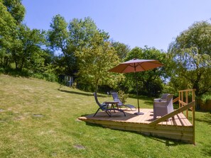 A wooden deck with outdoor furniture, including two chairs and a table, under a large umbrella. - 1 Bed in Bridport (oc-dc113) (West Milton)