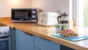 Eine Küche mit Mikrowelle, Toaster und Kaffeemaschine auf der Arbeitsfläche.