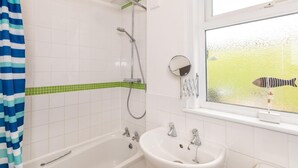 Ein Badezimmer mit Badewanne, Waschbecken, Dusche und einem Fenster mit Blick auf einen Fisch.