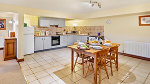 Cocina compacta con comedor, que incluye microondas, horno y salpicadero de azulejos.