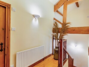 Eine Holztreppe mit Heizkörper und Blumentopf.
