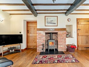 A living room with a fireplace, wooden beams, a flat-screen TV, and a patterned rug. - 3 Bed in Tenbury Wells (oc-94240) (Rochford)