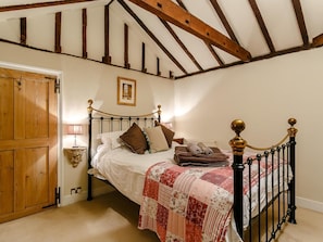 A bedroom with a bed, wooden door, and a framed picture on the wall. - 6 Bed in Winchelsea (oc-77281) (Icklesham)