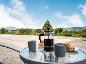 A round glass table with a French press, two cups, and a plate of pastries. - 1 Bed in Biggar (oc-82923) (Biggar)