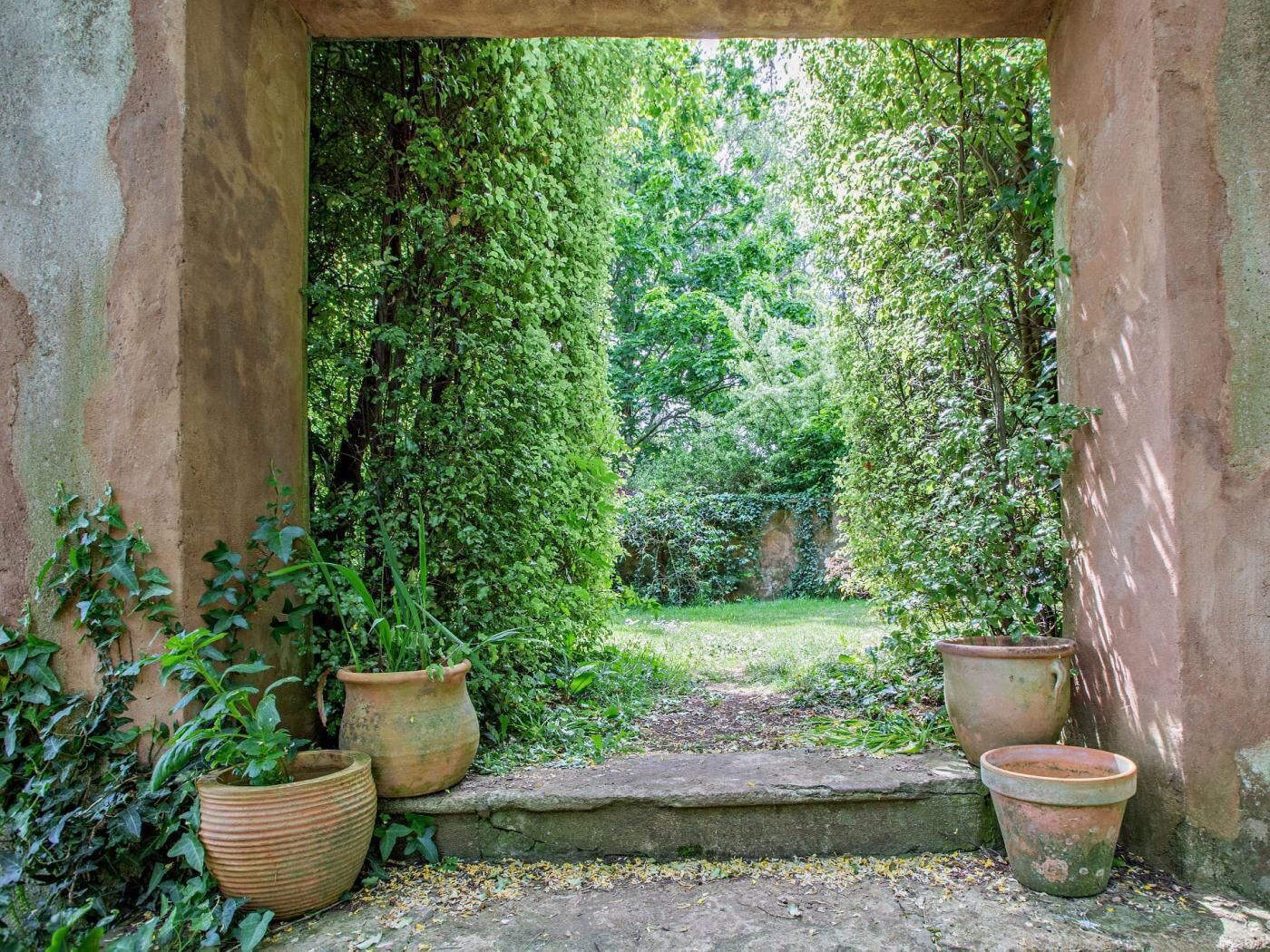 Um arco de pedra com vista para um jardim exuberante.