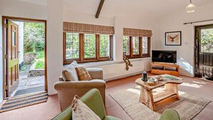 Ein Wohnzimmer mit einer Couch, einem Couchtisch, einem Fernseher und einem Kamin.