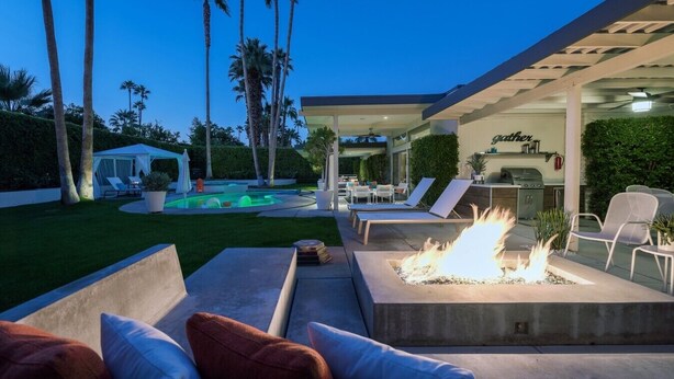 Eine Terrasse mit Sitzgelegenheit im Freien, einem Feuerbereich und einem Pool.