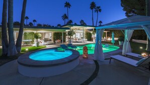 Ein Poolbereich mit Liegestühlen und einer Pergola.