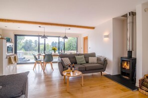 A modern living room with a sofa, coffee table, and a fireplace.