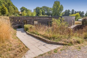 A building with a curved pathway leading to a wooden door. - 3 Bed in Tiverton (oc-59635) (Whitnage)