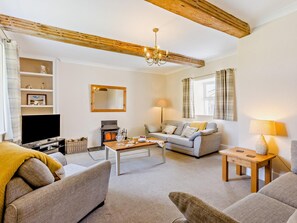 Una sala de estar con chimenea, sofá y televisor.