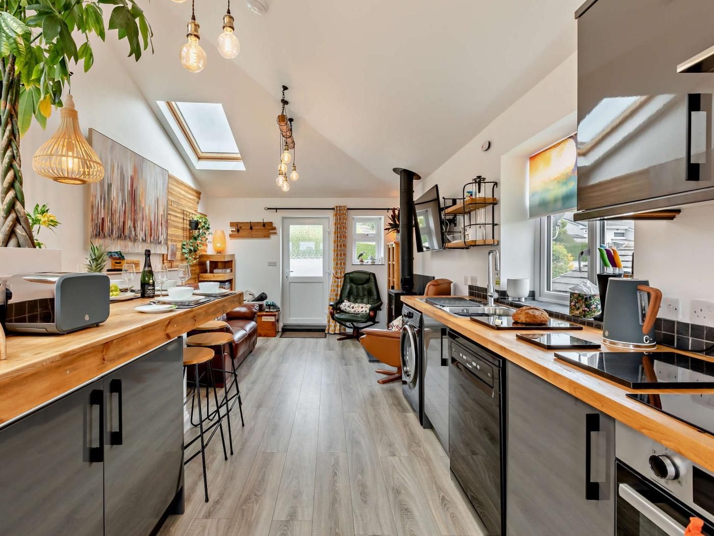 A modern kitchen with a central island, built-in appliances, and a dining area with a view to the outdoors.