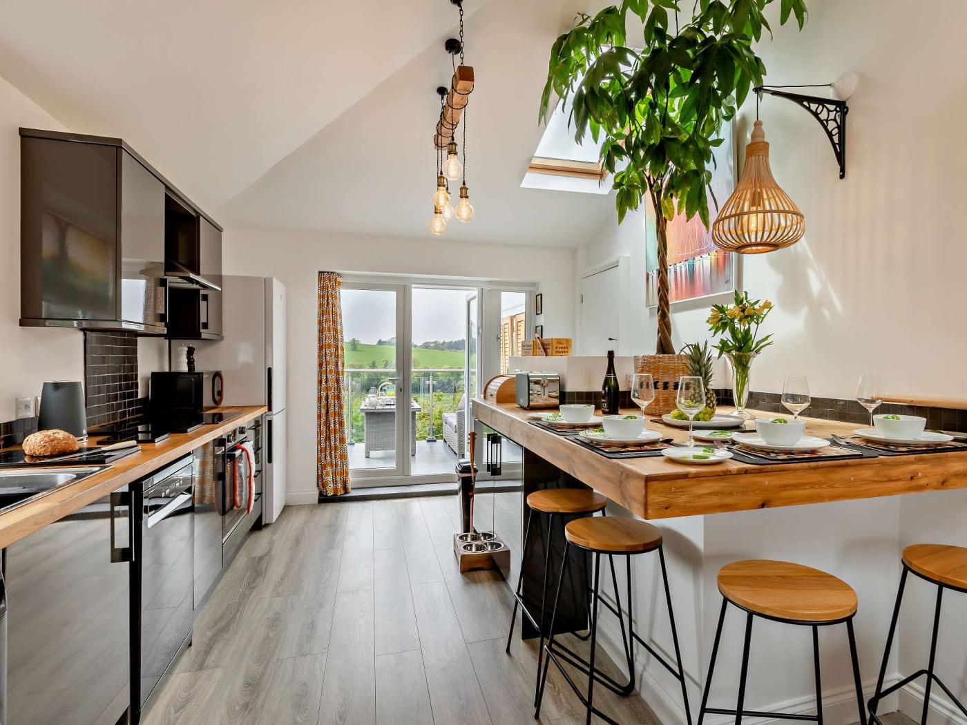 Een moderne keuken met een groot eiland, barstoelen en uitzicht op het omliggende landschap.