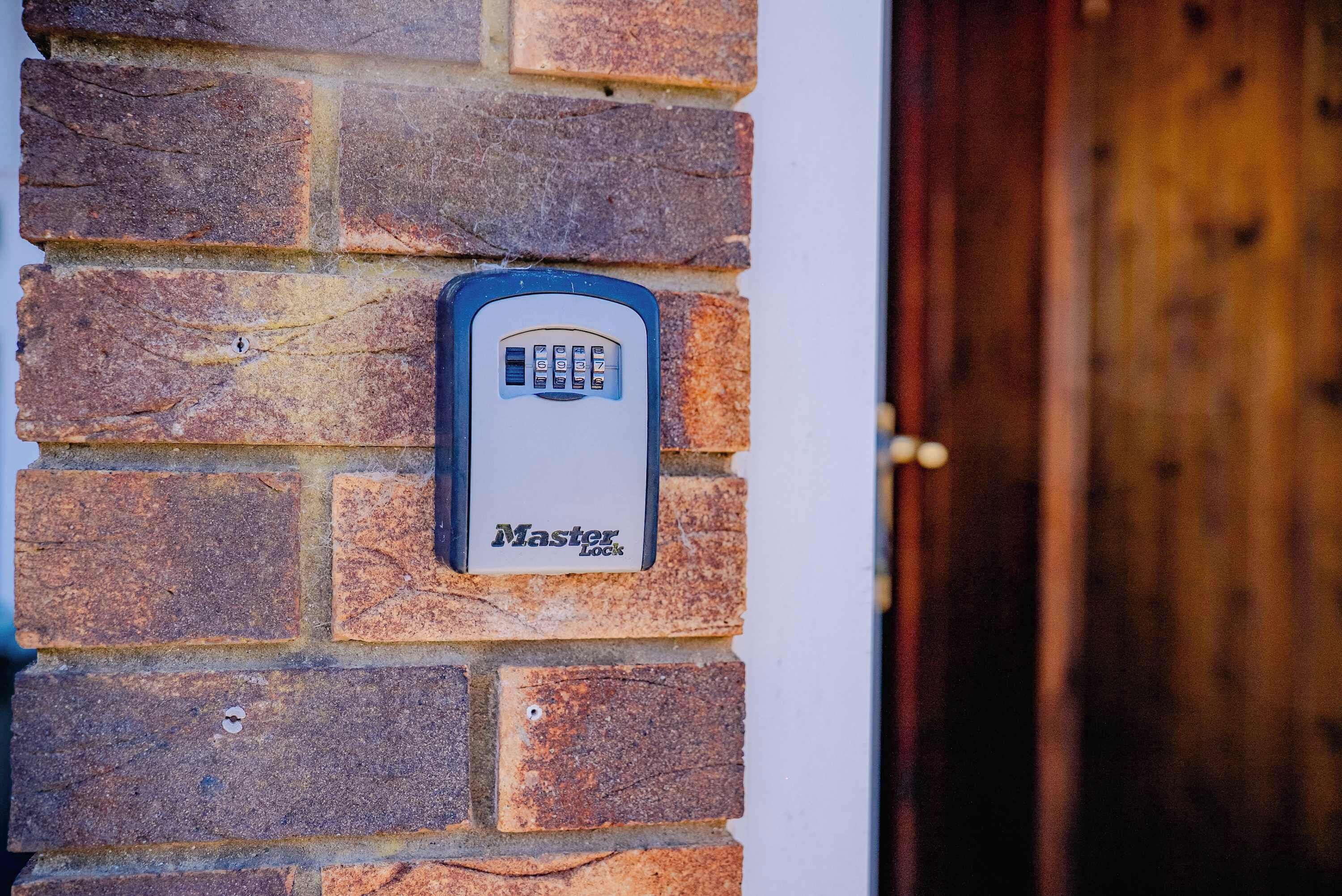 Un candado Master Lock sujeto a una pared de ladrillo.