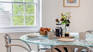 A breakfast table with croissants, a coffee pot, and a vase of flowers. - 1 Bed in Sherborne (oc-94306) (Chetnole)